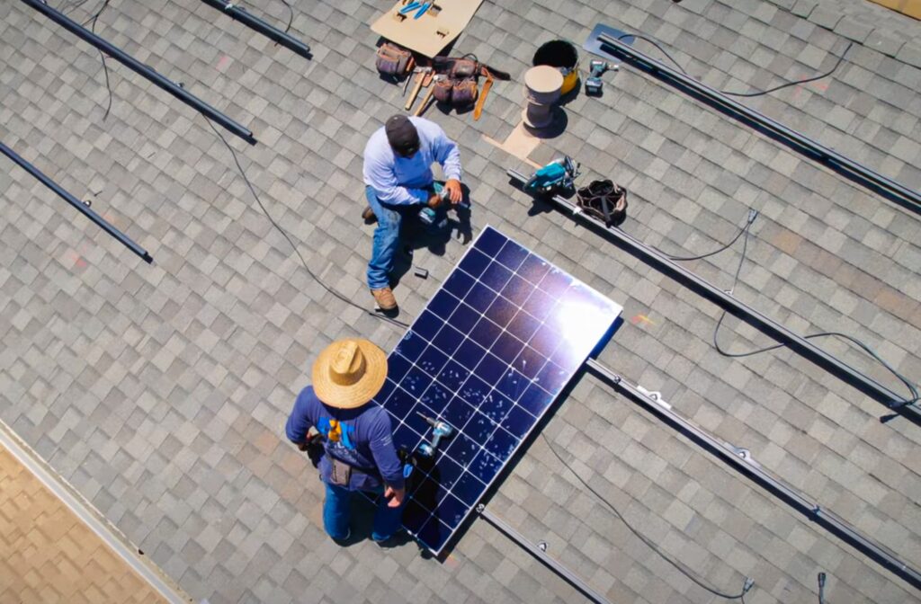 Technicians performing solar panel removal and reinstallation on a Southern California roof