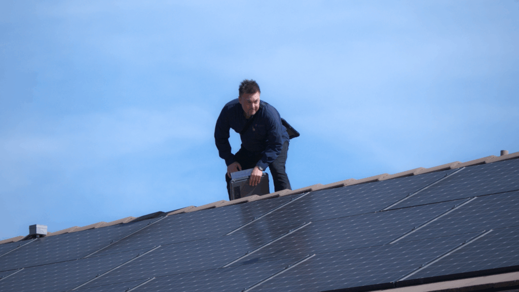 Technician performing solar panel removal and reinstallation on a Southern California home