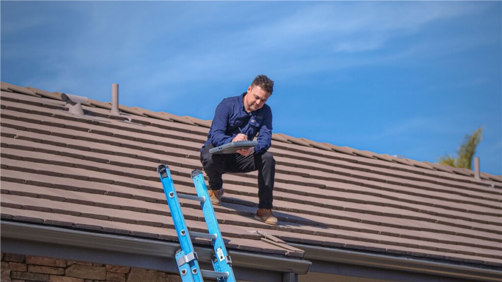 Roof technician inspecting tile roof for cleaning and repair services