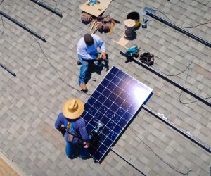 Technicians performing solar panel removal and reinstallation on a Southern California roof
