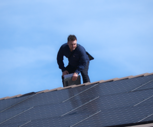 Technician performing solar panel removal and reinstallation on a Southern California home