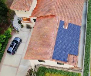 Residential solar system repair on rooftop solar panels by August Roofing technician