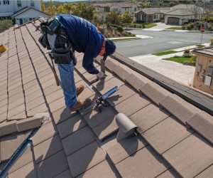Technician securing roof tiles as part of home hardening and wildfire protection services in Southern California