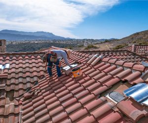Technician installing ember-resistant roof vents during home hardening and wildfire protection services in Southern California