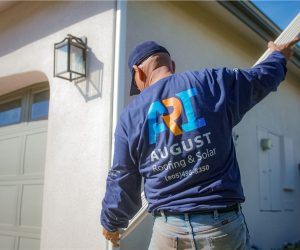 August Roofing & Solar technician wearing company uniform while performing gutter cleaning services in Southern California
