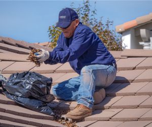 Roof cleaning & tile repair service being performed by August Roofing technician