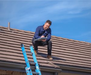 Roof technician inspecting tile roof for cleaning and repair services