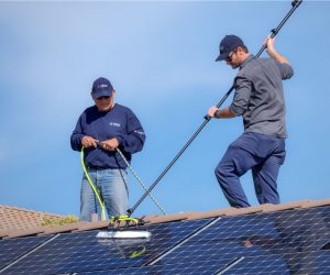 Technicians performing solar system repair and maintenance on rooftop solar panels